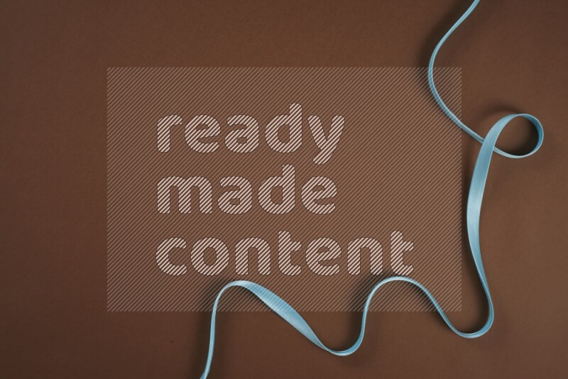 مجموعة من أدوات الخياطة والتفصيل زرقاء اللون على خلفية بنية