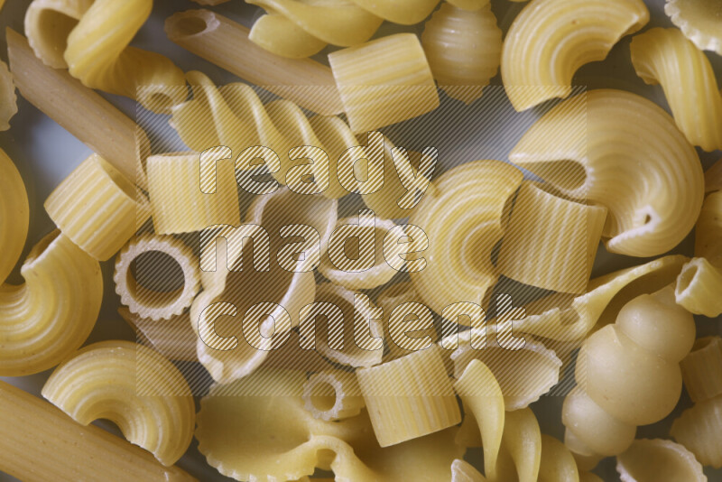 Different pasta types on light blue background
