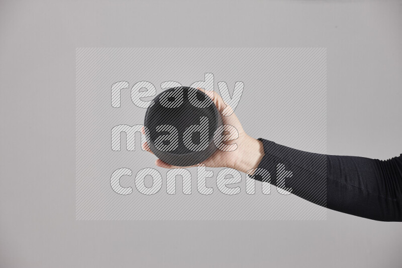 امرأة ترتدي عباءة سوداء تحمل أدوات فخارية مختلفة في أوضاع متعددة