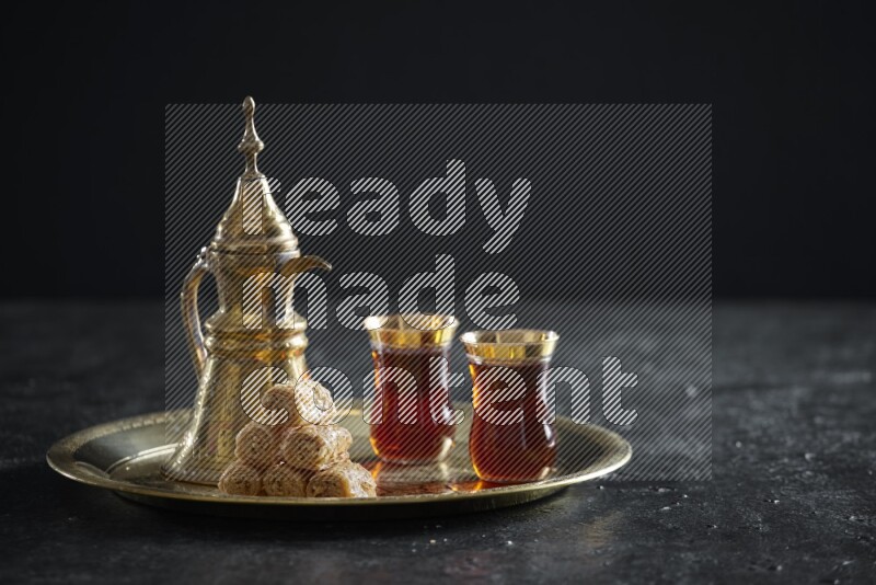 Golash with a drink on a metal tray in a dark setup