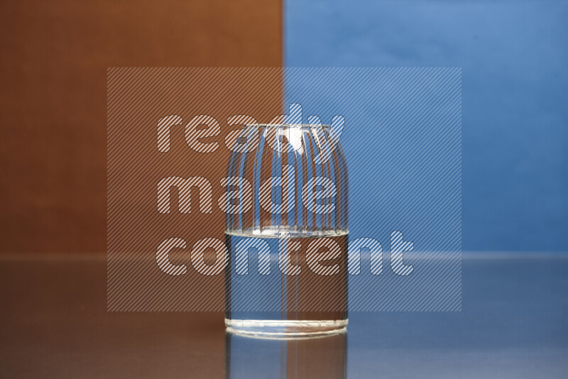 The image features a clear glassware filled with water, set against brown and blue background