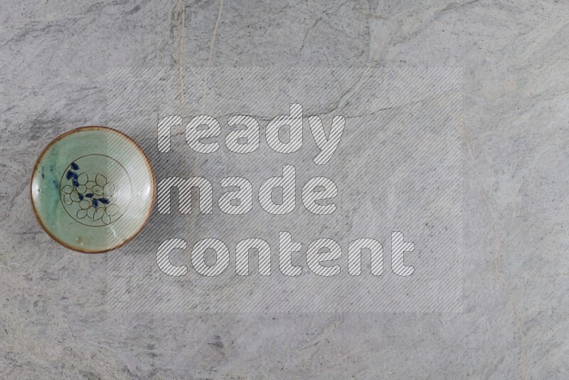 A decorative pottery plate on grey marble background