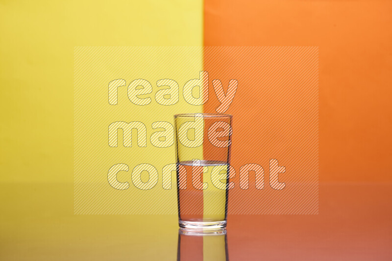 تظهر الصورة أواني زجاجية ممتلئة بالماء موضوعة على خلفية من اللونين الأصفر والبرتقالي
