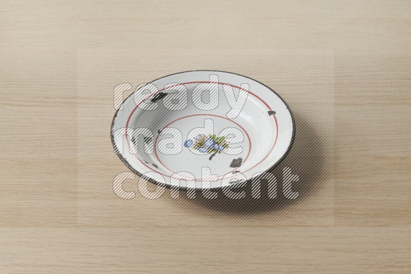 صحن معدني عتيق على خلفية خشبية فاتحة