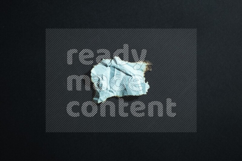 Burnt multicolored paper on black background