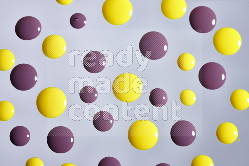 Close-ups of abstract purple and yellow paint droplets on the surface