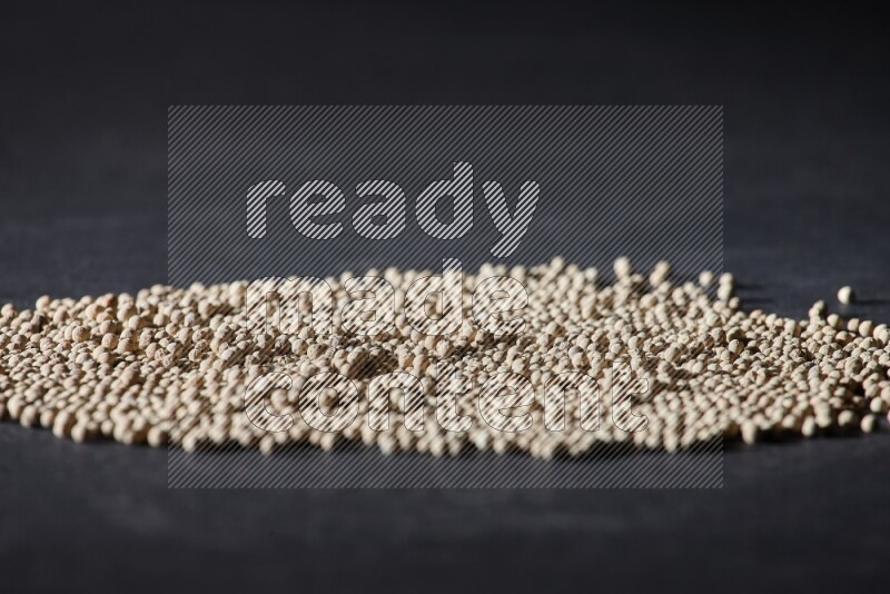 White pepper beads on black flooring