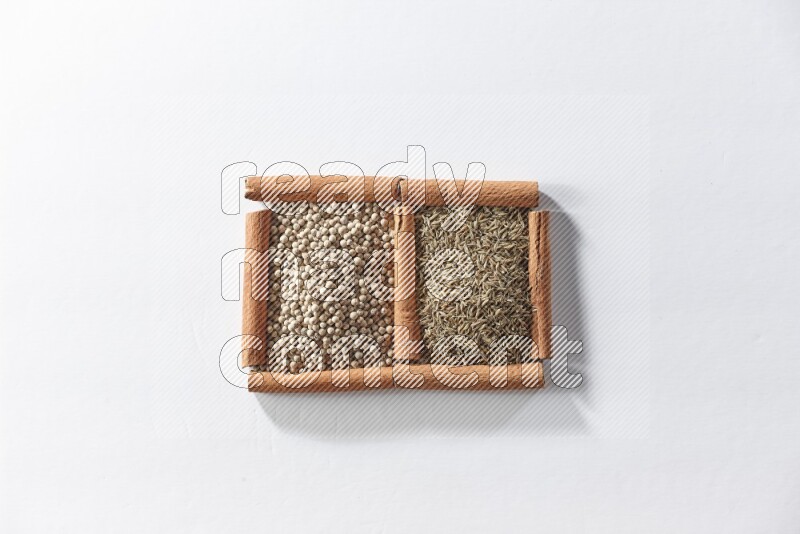 2 squares of cinnamon sticks full of white pepper and cumin on white flooring