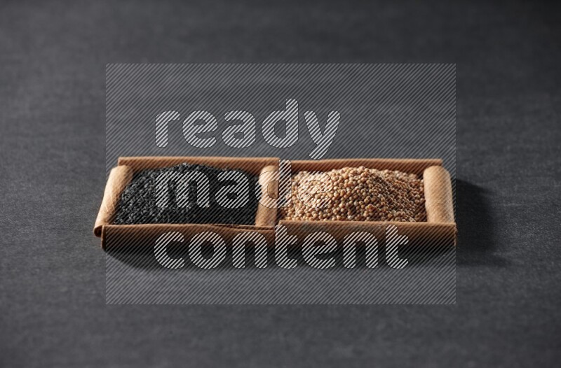2 squares of cinnamon sticks full of mustard seeds and black seeds on black flooring
