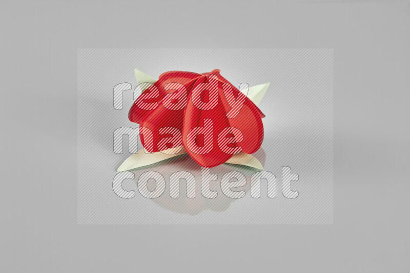 Origami flower on grey background