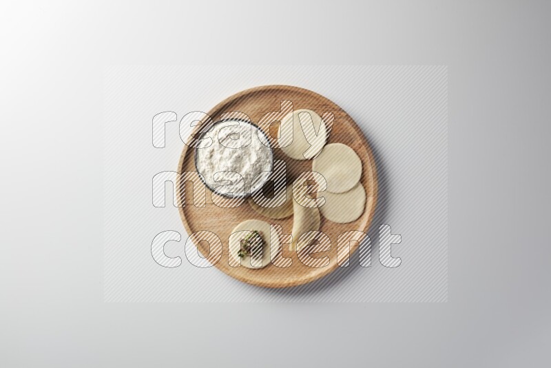 two closed sambosas and one open sambosa filled with meat while flour aside in a wooden dish on a white background