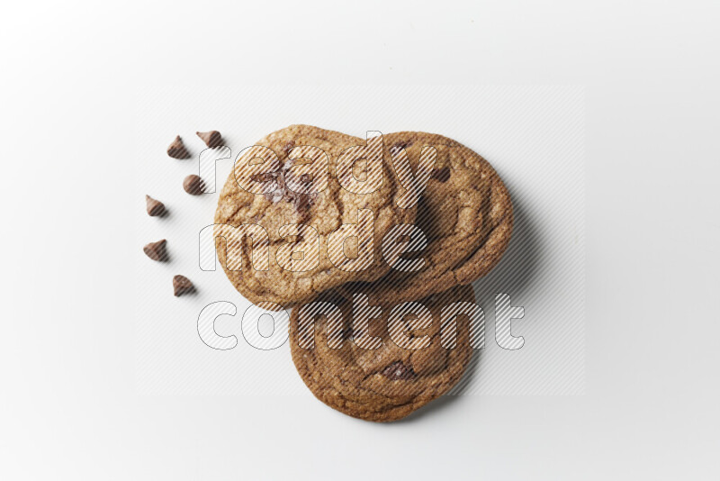 Chocolate chips cookies with chocolate beside it on a white background