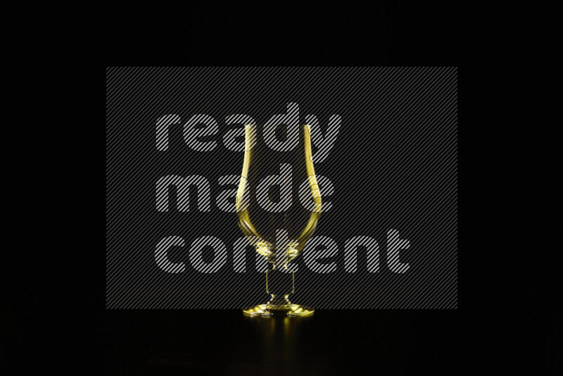 Glassware with rim light in yellow against black background