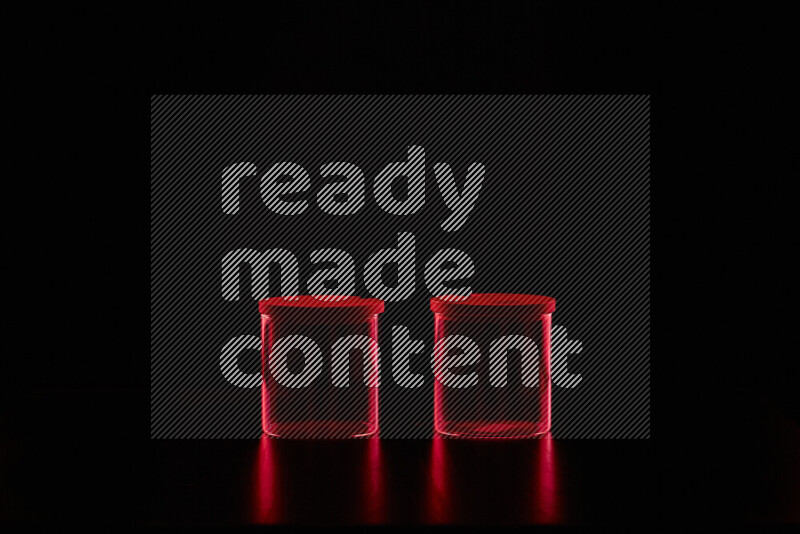 Glassware with rim light in red against black background