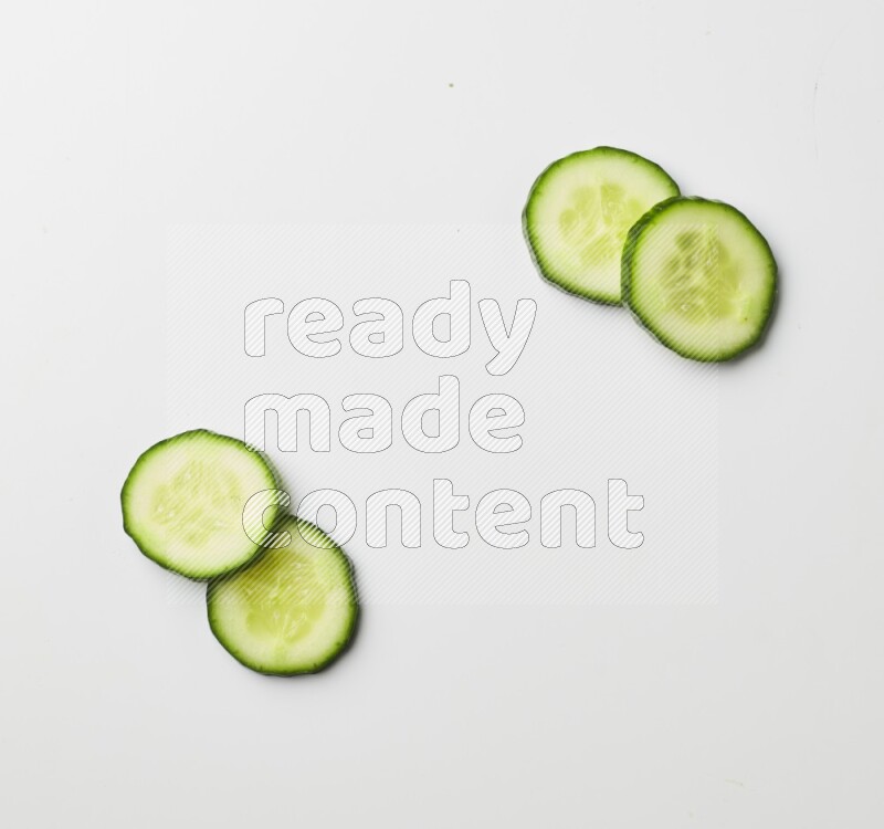 Multiple cucumber slices on white background