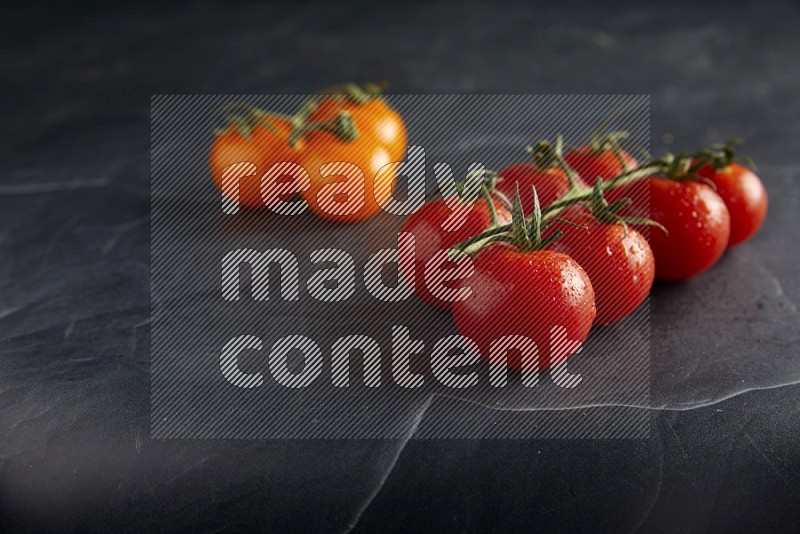 Mixed cherry tomato veins on a textured black slate background 45 degree