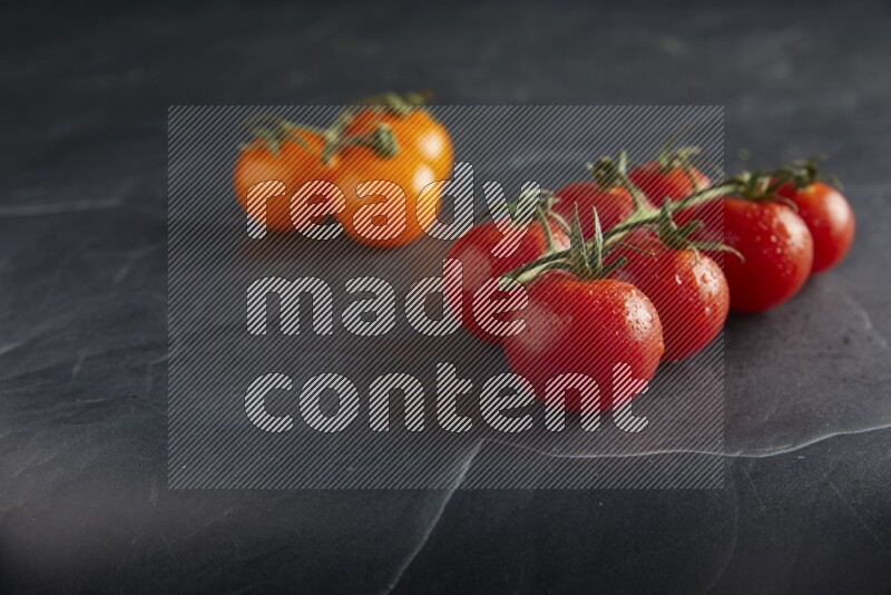 Mixed cherry tomato veins on a textured black slate background 45 degree