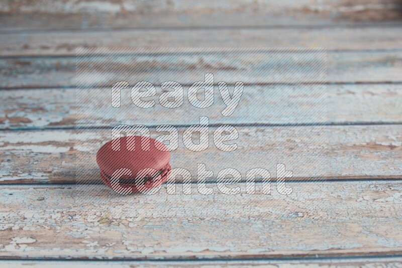 45º Shot of Red Cherry macaron on light blue wooden background