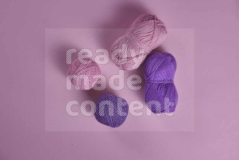 مجموعة من أدوات الخياطة والتفصيل أرجوانية وزهرية اللون على خلفية زهرية