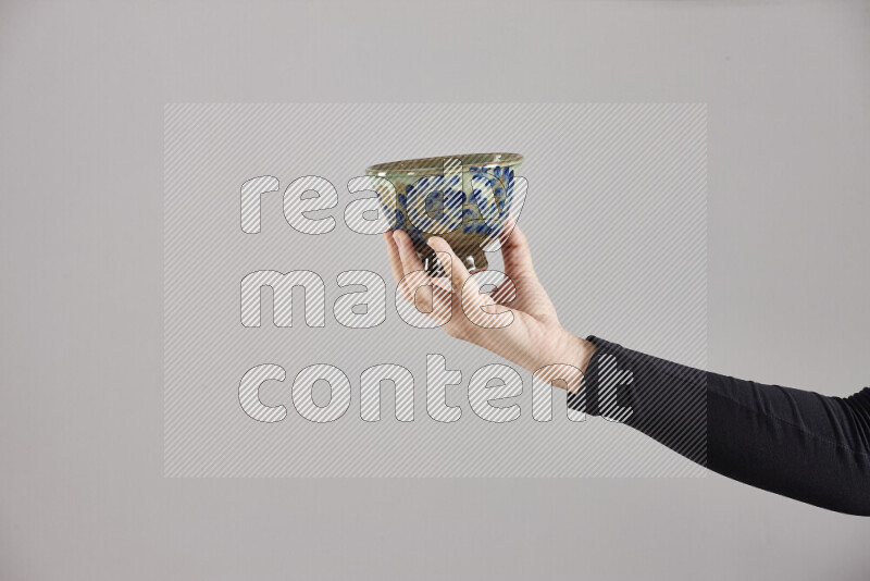 A woman in black abaya holding different pottery essentials in different positions