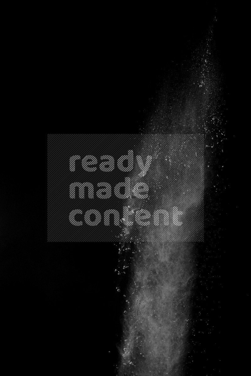 A side view of white powder explosion on black background