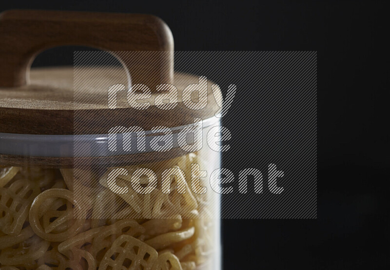 Snacks in a glass jar on black background