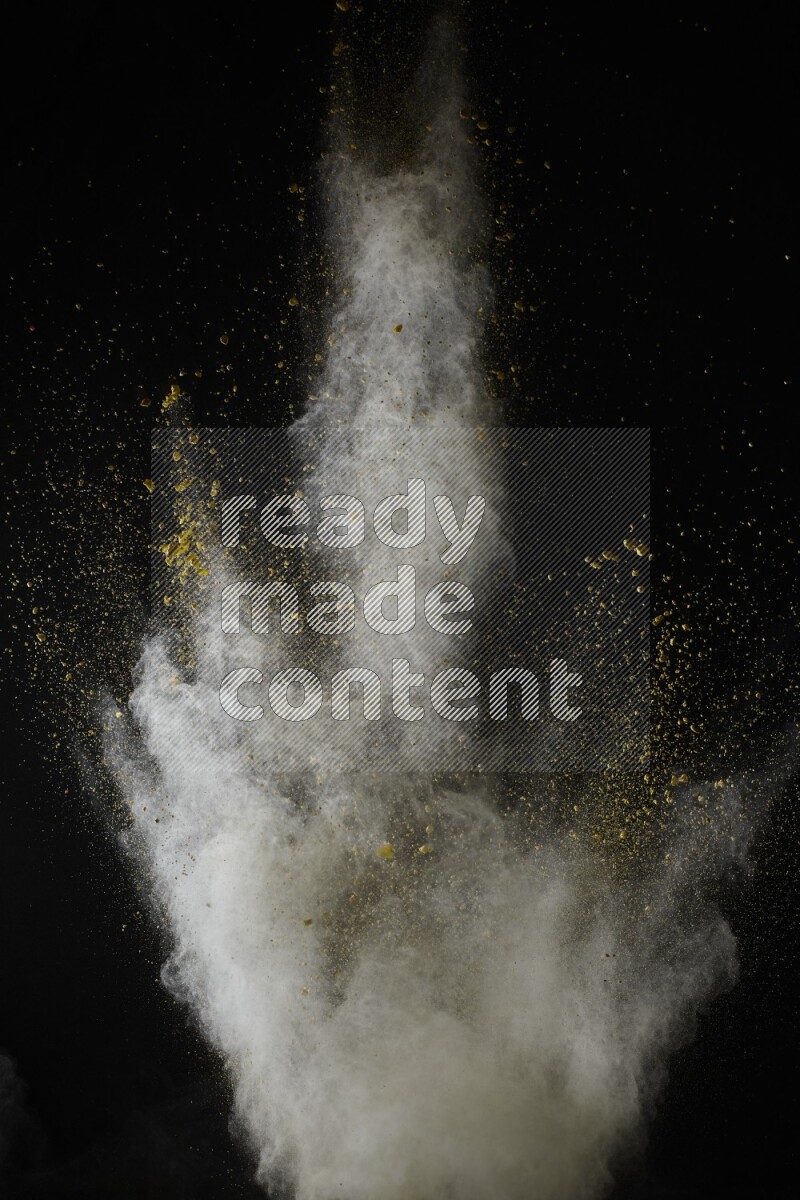 A side view of yellow powder explosion on black background