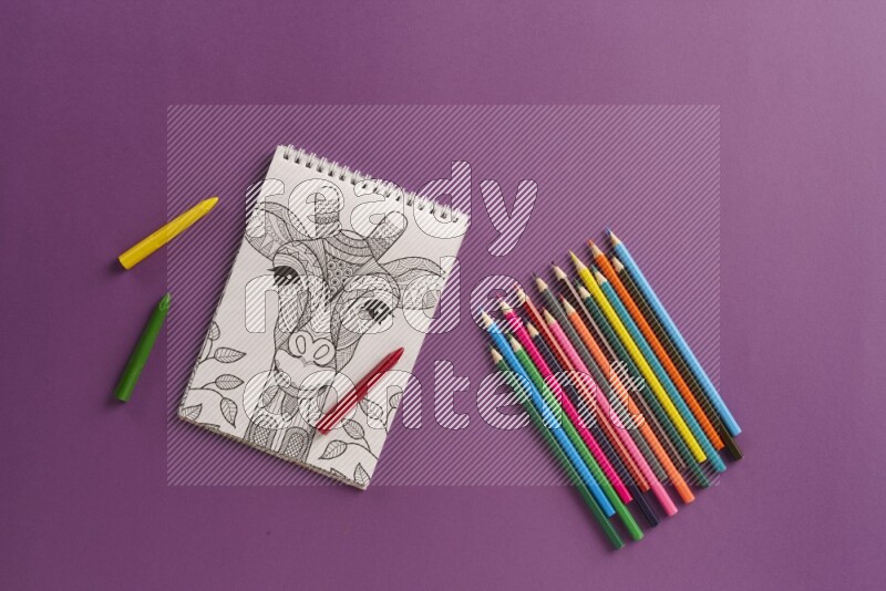 A coloring book with coloring pens on purple background