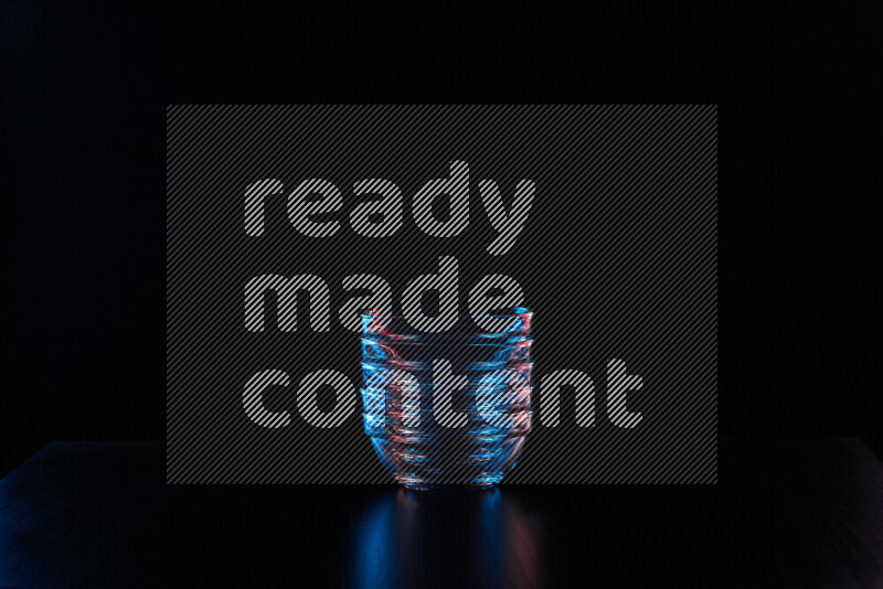 Glassware with rim light in red and blue against black background