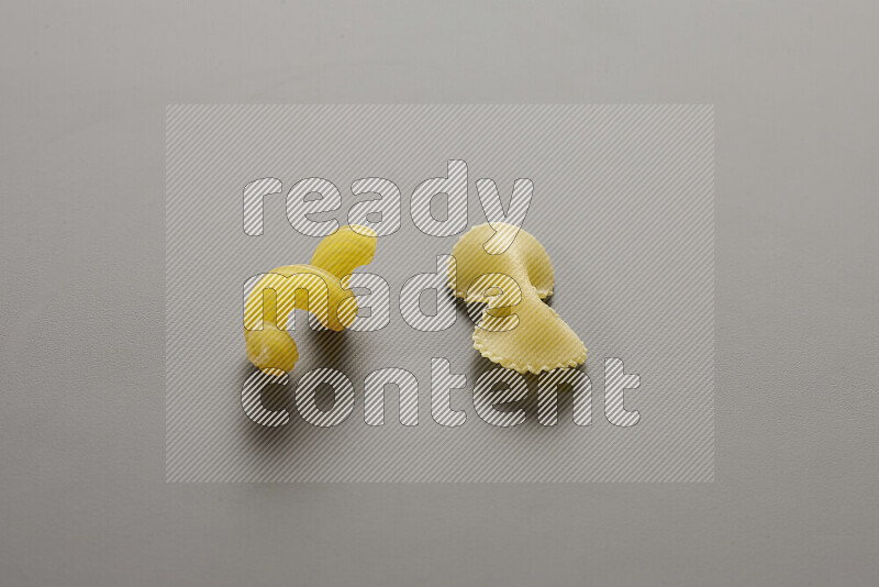 Twist pasta with other types of pasta on grey background