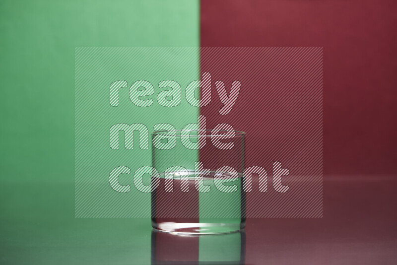 The image features a clear glassware filled with water, set against green and dark red background