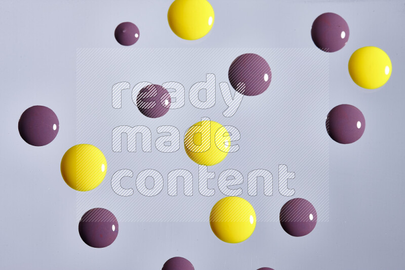 Close-ups of abstract purple and yellow paint droplets on the surface