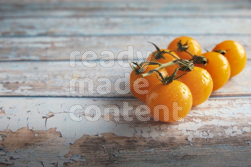 yellow cherry tomato vein on a textured blue wooden background 45 degree