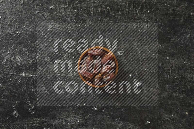 تمر في أطباق خشبية علي خلفية سوداء