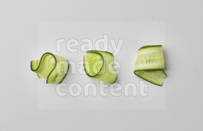 Three cucumber ribbons on a white background