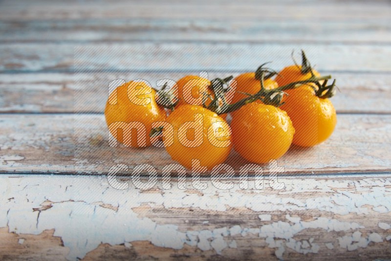 yellow cherry tomato vein on a textured blue wooden background 45 degree