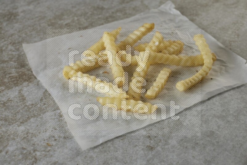 crinkle fries on parchment paper on grey textured counter top