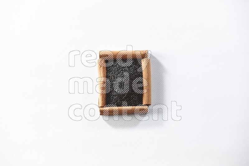 A single square of cinnamon sticks full of black seeds on white flooring