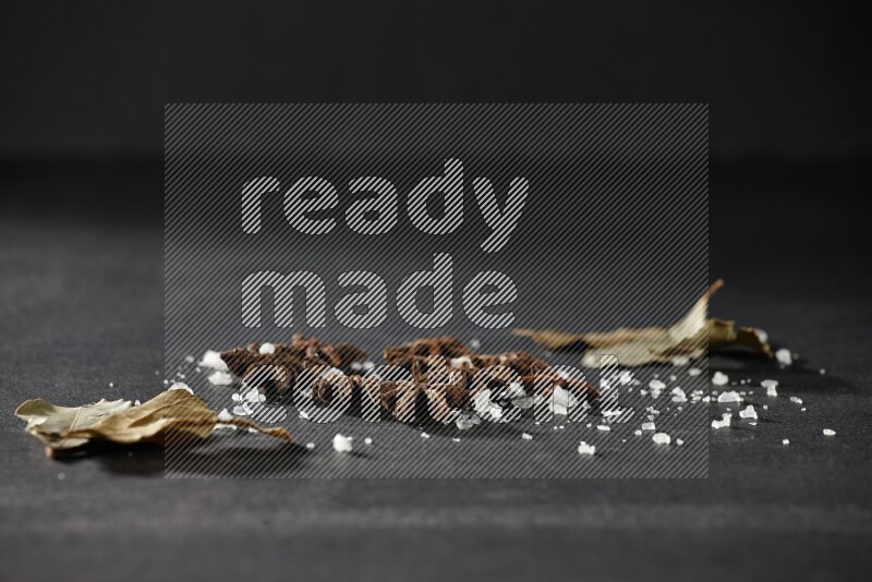 الملح واليانسون النجمي وورق الغار على خلفية سوداء