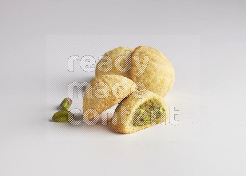 Four Pieces of Maamoul filled with pistachio  paste one of them is cut direct on white background