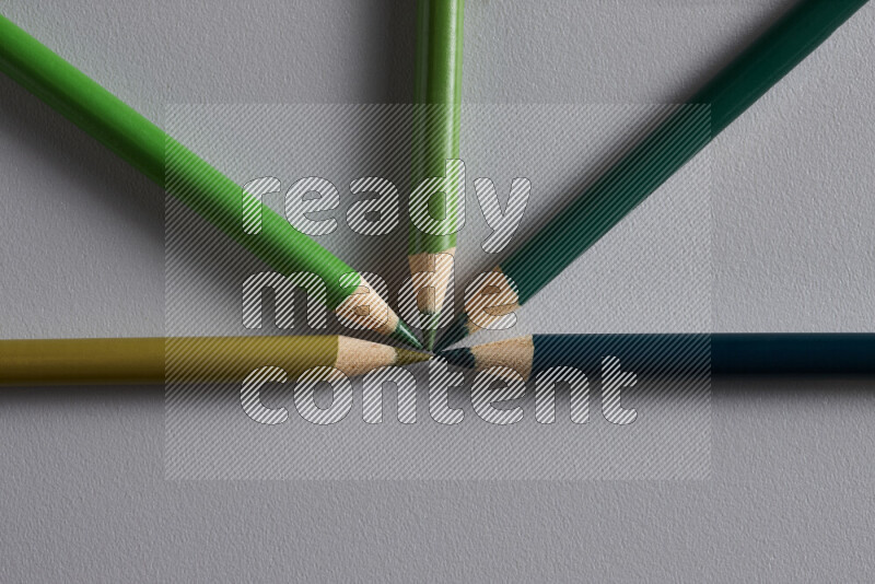 An arrangement of colored pencils in different colors on grey background