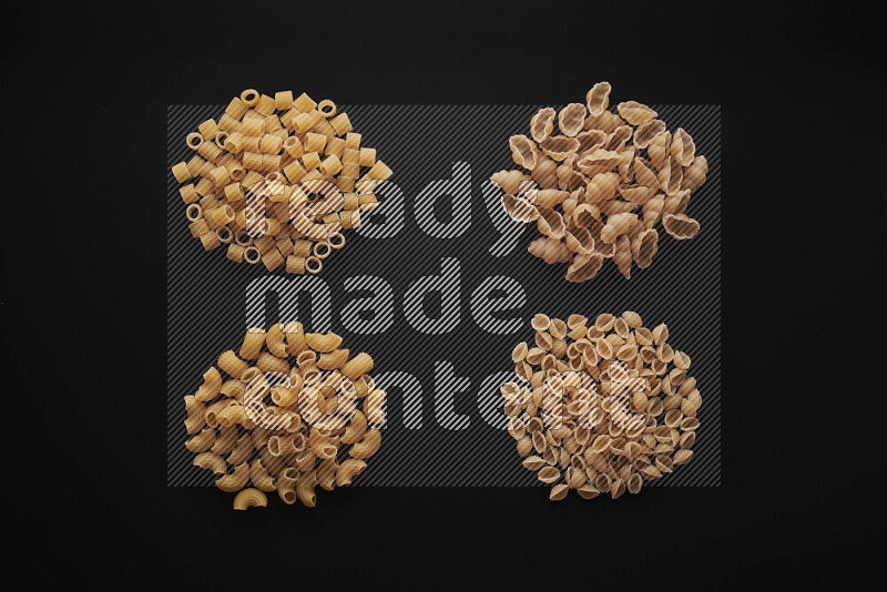 Different pasta types in bunches on black background