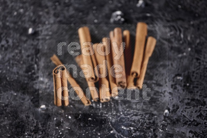 Cinnamon sticks on a textured black background