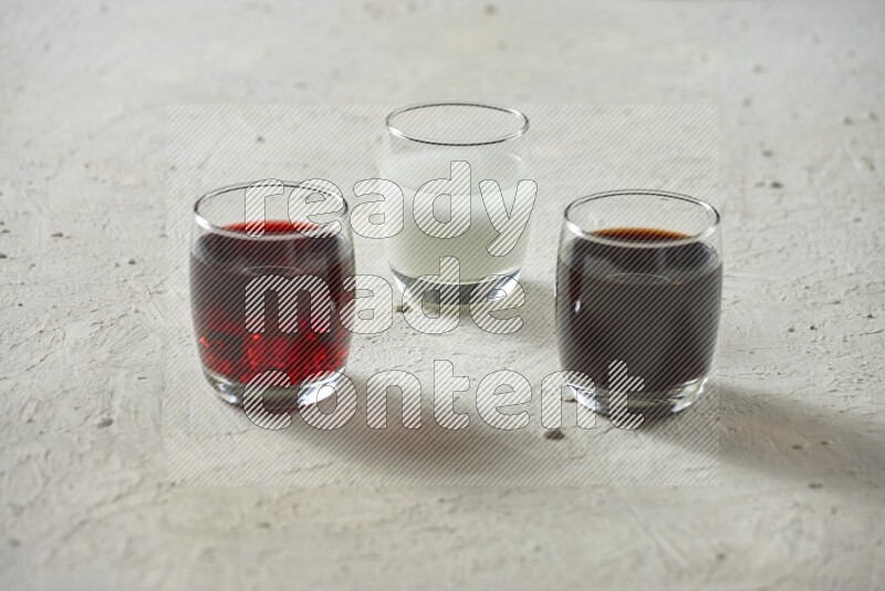 Cold drinks in a glass cup such as water, tamarind, qamar eldin, sobia, milk and hibiscus on textured white background