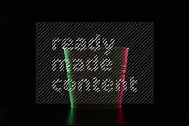 A plant pot with colored rim light against black background