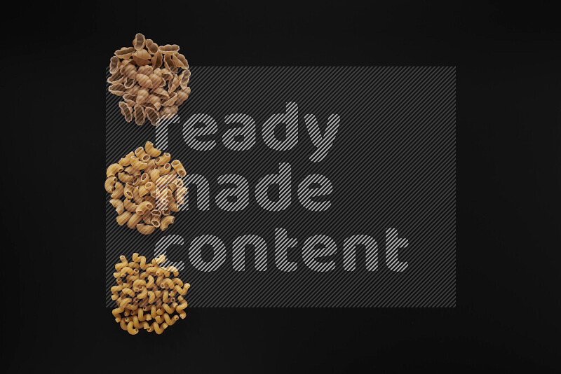 Different pasta types in 3 bunches on black background