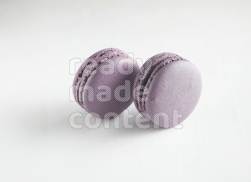 45º Shot of two Purple Blueberry macarons on white background