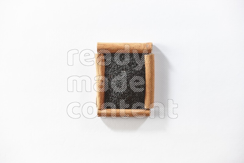 A single square of cinnamon sticks full of black seeds on white flooring