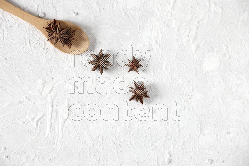 Star Anise in a wooden spoon on white flooring