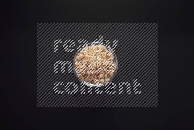 معكرونة ودعة في وعاء زجاجي علي خلفية سوداء